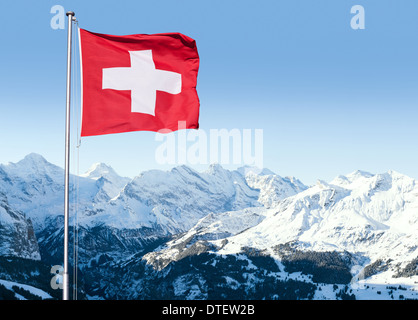 Le drapeau de la Suisse en volant dans le vent avec les Alpes Bernoises à l'arrière-plan, Grindelwald, Suisse. Banque D'Images