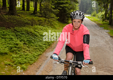 Femme vtt par route forestière motion blur Banque D'Images