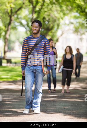 Smiling Male Student Walking on Campus Road Banque D'Images