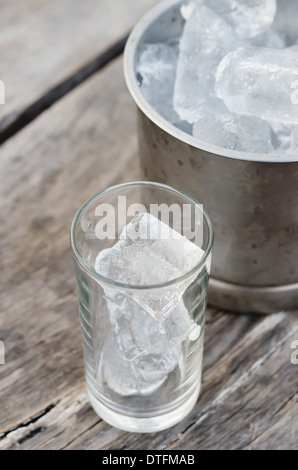 Verre avec des glaçons et seau à glace rempli de glaçons Banque D'Images