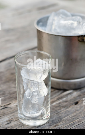 Verre avec des glaçons et seau à glace rempli de glaçons Banque D'Images