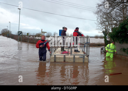 Les bénévoles à l'aide d'un flottant dans à convoyer du matériel autour des inondations en Burrowbridge Somerset Levels. Banque D'Images
