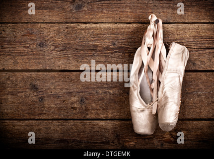 Chaussures de ballet rose vieille pendaison sur fond de bois Banque D'Images