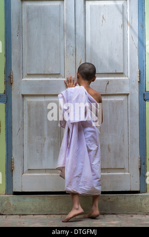 MANDALAY, MYANMAR - CIRCA DÉCEMBRE 2013 : Débutant la fermeture d'une porte, dans un monastère de Amarpura Banque D'Images