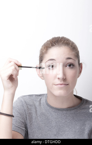 Teenage girl applying mascara Banque D'Images