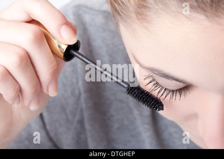 Teenage girl applying mascara Banque D'Images