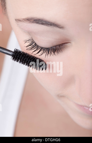 Teenage girl applying mascara Banque D'Images