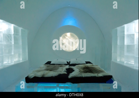 Artistiquement décorées prix fait de glace, d'un lit double avec fourrure de renne, Jukkasjärvi Icehotel, Laponie, Suède, comté de Norrbotten Banque D'Images