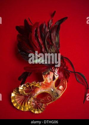 Un rouge, or et noir mardi gras ou masque de Venise sur un fond rouge Banque D'Images