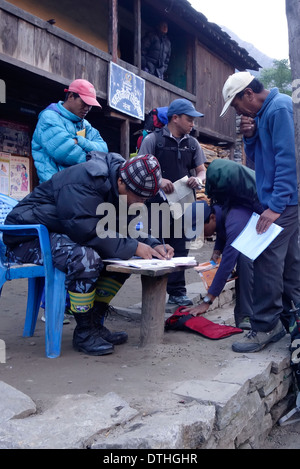 Guides de trekking de l'enregistrement à un poste de contrôle du village de Philim sur la route de trekking Manaslu, au Népal. Banque D'Images