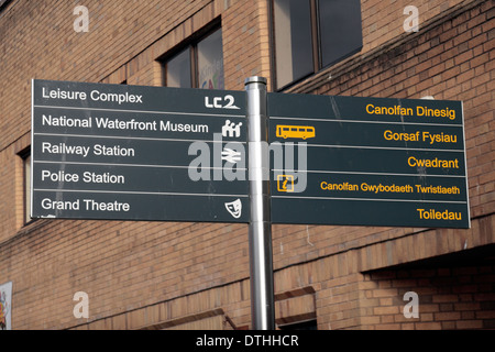 Langue double panneau piéton avec l'anglais d'un côté et de l'autre gallois (English, Welsh blanc jaune) Swansea, Pays de Galles. Banque D'Images