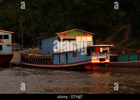 Bateaux le long de la rive du Mékong au coucher du soleil, le Laos. Banque D'Images