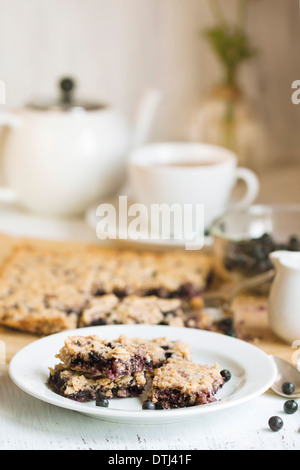 Le petit-déjeuner composé de tarte aux bleuets, sur plaque blanche, bol de bleuets frais et tasse de thé blanc Banque D'Images