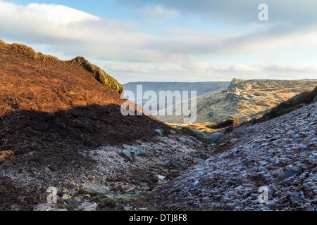 La fonte du givre en hiver soleil dans un ravin de la tourbe. Fairbrook sur le bord nord  ? De Kinder Scout, le bord du joint dans la distance, England, UK Banque D'Images