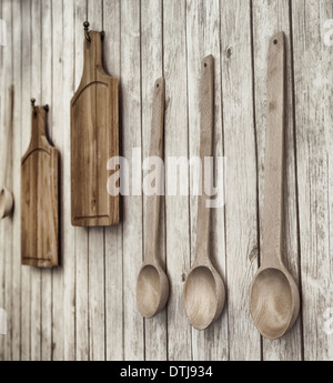 Vintage photo stylisée de planches à découper et les cuillères en bois accroché au mur, des ustensiles de cuisine Banque D'Images