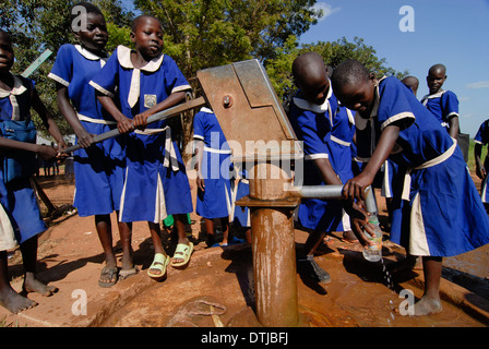 Kitgum, Ouganda école de filles de l'église catholique, les filles en bleu de l'uniforme scolaire aller chercher de l'eau potable provenant de la pompe à main Banque D'Images