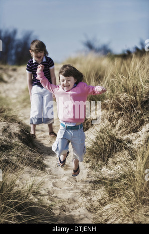 Deux jeunes enfants jouant dans les dunes en Angleterre Banque D'Images