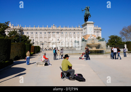 Madrid, Espagne. Plaza de Oriente. Statue de Felipe / Philippe IV (Pietro Tacca, 1639) Palais Royal et musicien ambulant jouant de la guitare Banque D'Images