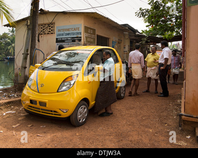 L'Inde, le Kerala, backwaters, jaune voiture Tata Nano on riverbank Banque D'Images