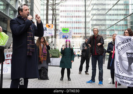 Siège social d'ATOS ORIGIN, London, UK, 19 février 2014. Comédien et activiste Mark Thomas parle à l'extérieur du siège social d'ATOS ORIGIN à Londres pour protester contre la mise en œuvre des travaux d'évaluation des capacités. Mobilité l'interprète et comédien Mat Fraser (deuxième à droite) à l'écoute de la foule. Les activistes ont appelé à l'abolition de l'évaluation de la capacité de travail et a déclaré qu'un médecin qualifié, idéalement le GP qui voit régulièrement et traite la personne malade ou handicapée en question, est la seule personne capable de décider si une personne est apte au travail. Credit : Patricia Phillips/Alamy Live News Banque D'Images