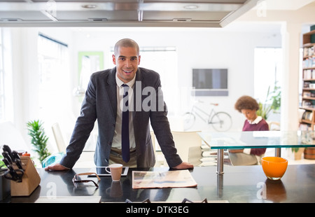 Businessman reading newspaper at table Banque D'Images