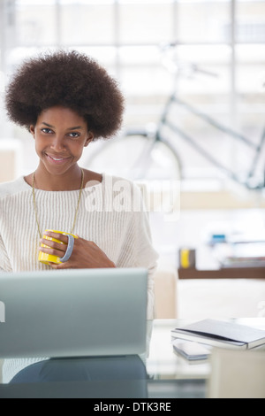 Woman using laptop at desk Banque D'Images