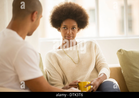 Couple drinking coffee sur canapé Banque D'Images