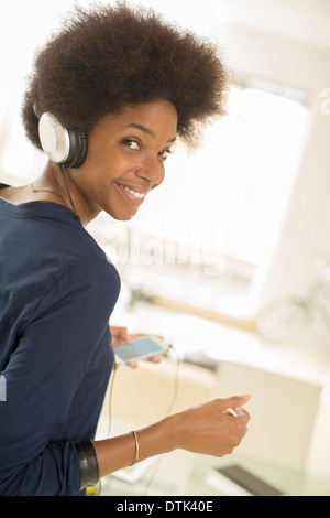 Woman listening to headphones on sofa Banque D'Images