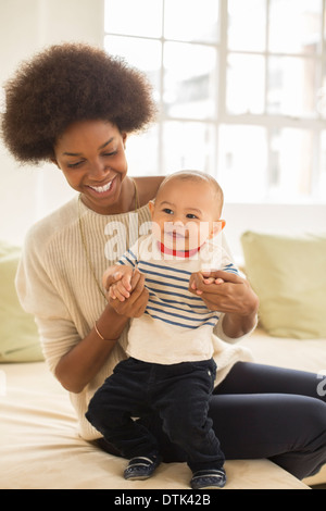 Mère et bébé garçon jouant sur canapé Banque D'Images