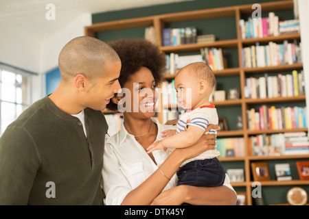 Couple holding baby in living room Banque D'Images