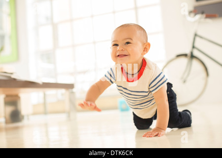 Baby Boy crawling sur plancher du salon Banque D'Images