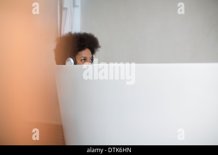 Woman listening to headphones in bath Banque D'Images