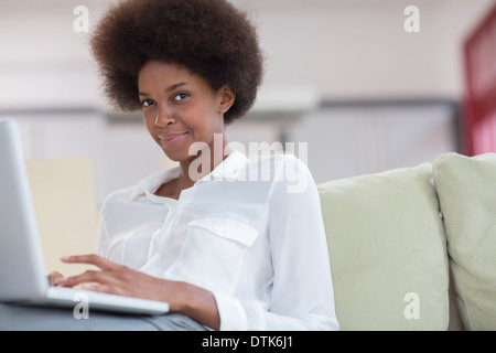 Businesswoman using laptop on sofa Banque D'Images