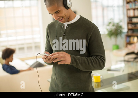 Man listening to headphones in living room Banque D'Images