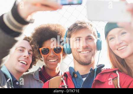 Les amis prendre des auto-portraits avec les téléphones avec appareil photo à l'extérieur Banque D'Images