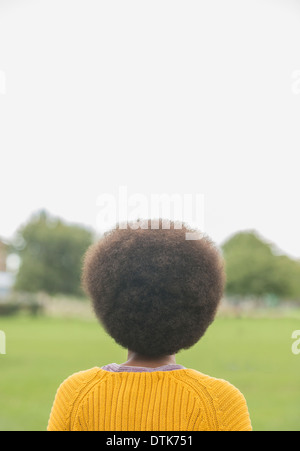 Femme avec afro standing in park Banque D'Images