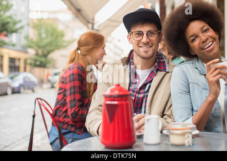 Couple drinking coffee at sidewalk cafe Banque D'Images