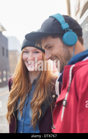 Couple laughing together on city street Banque D'Images