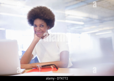 Businesswoman smiling at desk in office Banque D'Images