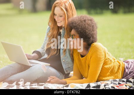 Women using laptop together in park Banque D'Images