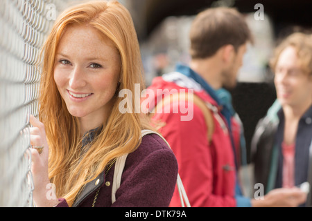 Woman smiling par Chain Link fence Banque D'Images