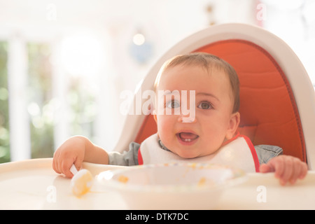 Baby Boy de manger dans une chaise haute Banque D'Images