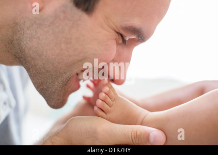 Father kissing Baby Boy's feet Banque D'Images