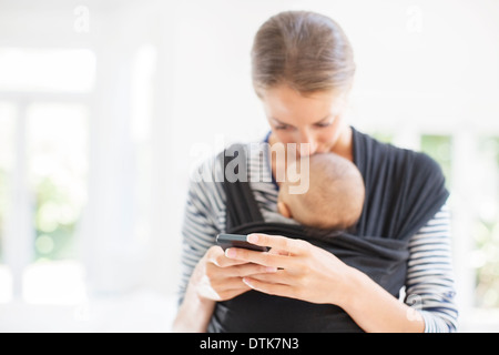 Mère avec baby boy using cell phone