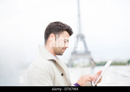 Businessman using digital tablet par Eiffel Tower, Paris, France Banque D'Images