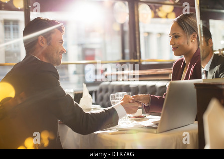 Business people shaking hands in restaurant Banque D'Images