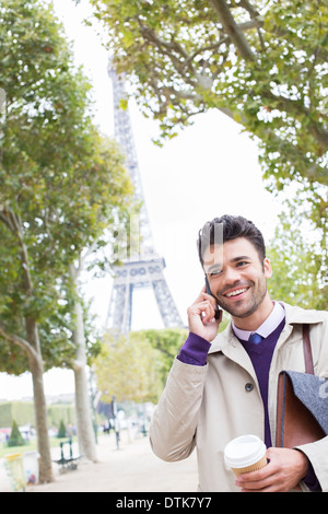 Businessman talking on cell phone near Eiffel Tower, Paris, France Banque D'Images