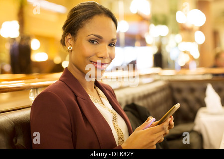 Businesswoman using cell phone in restaurant Banque D'Images