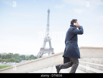 Businessman talking on cell phone et étapes ascendantes près de Eiffel Tower, Paris, France Banque D'Images