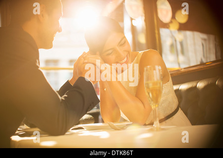 Couple holding hands in restaurant Banque D'Images